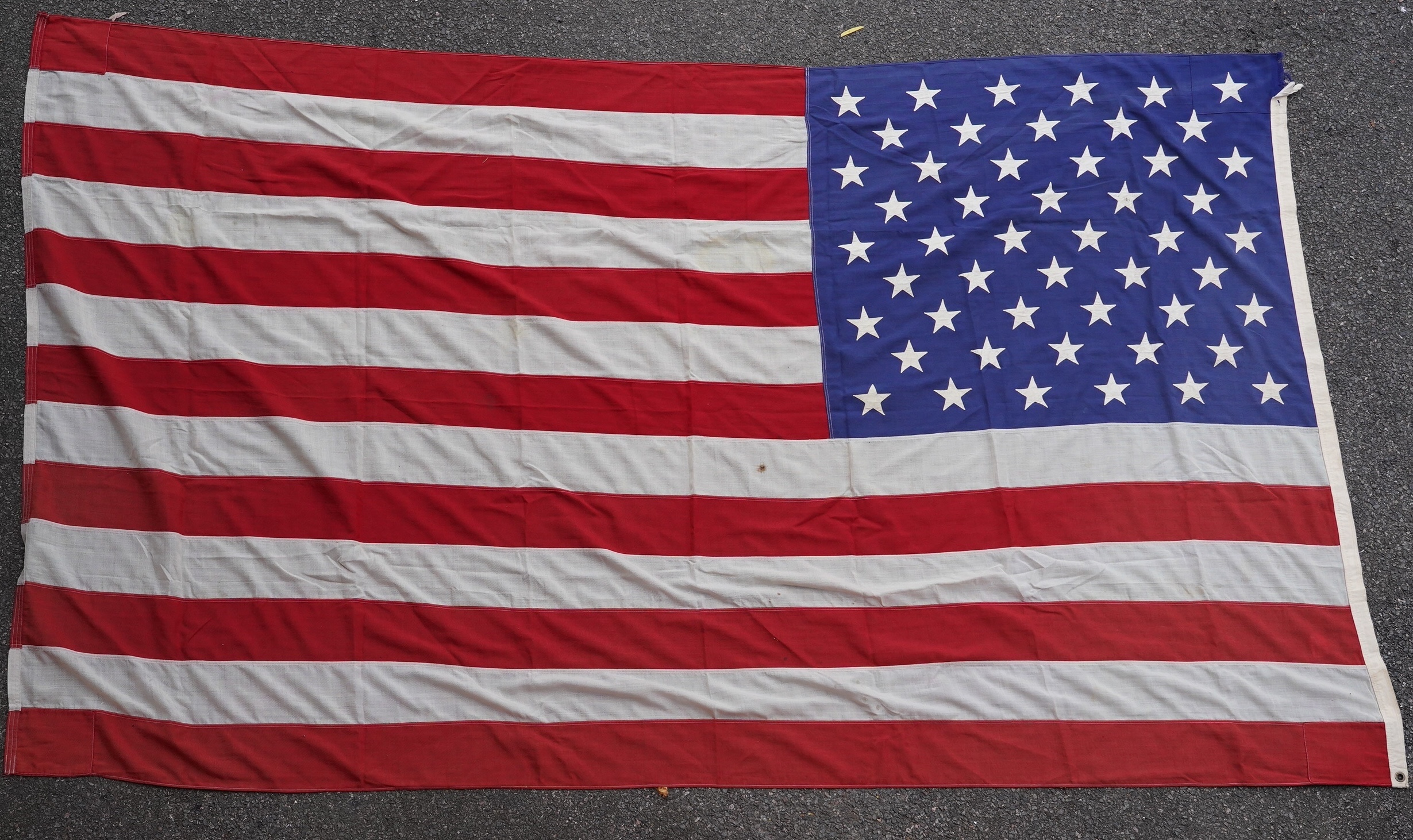 Four flags; two professionally made US Stars and Stripes, both on thick canvas with applied stars and joined stripes, one by the Valley Forge Flag Co., Pennsylvania, stamped “5 x 9.5 ft”, 146 x 288cm and 176 x 300cm, tog